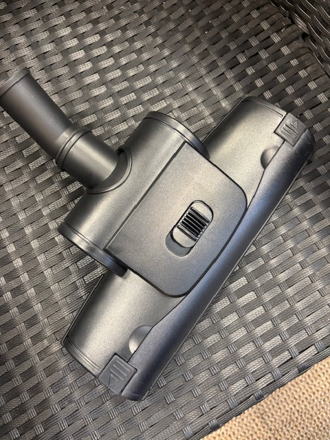 Gray vacuum cleaner head on a textured surface